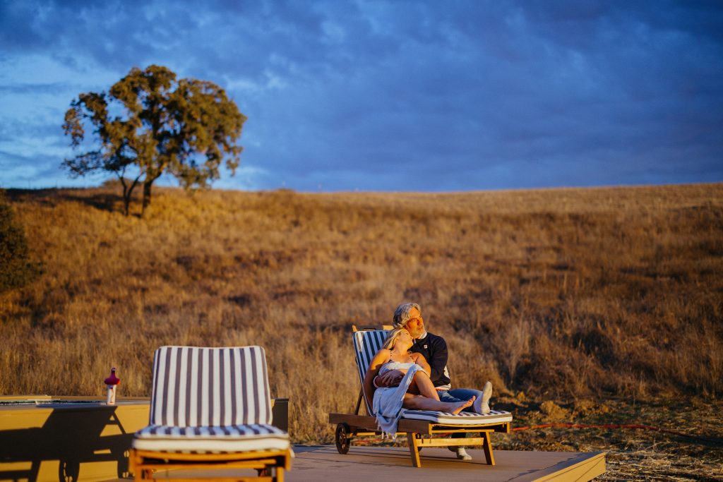 Couple relaxing outdoors at sunset.