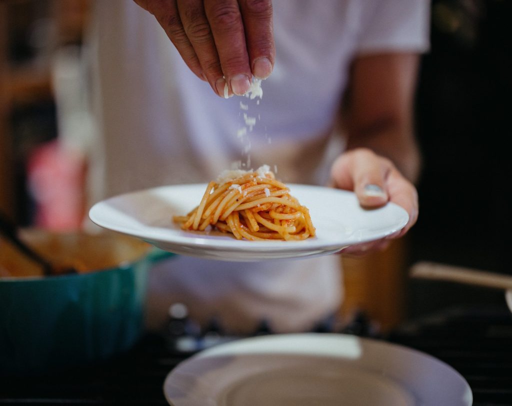 Sprinkling cheese on pasta plate
