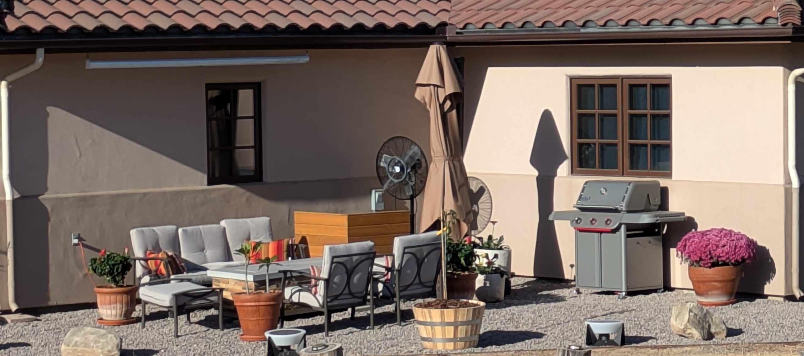 Cozy patio with grill and plants.